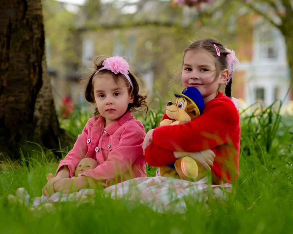 Anna and Dasha sitting on the grass - by Dick Lloyd Photography