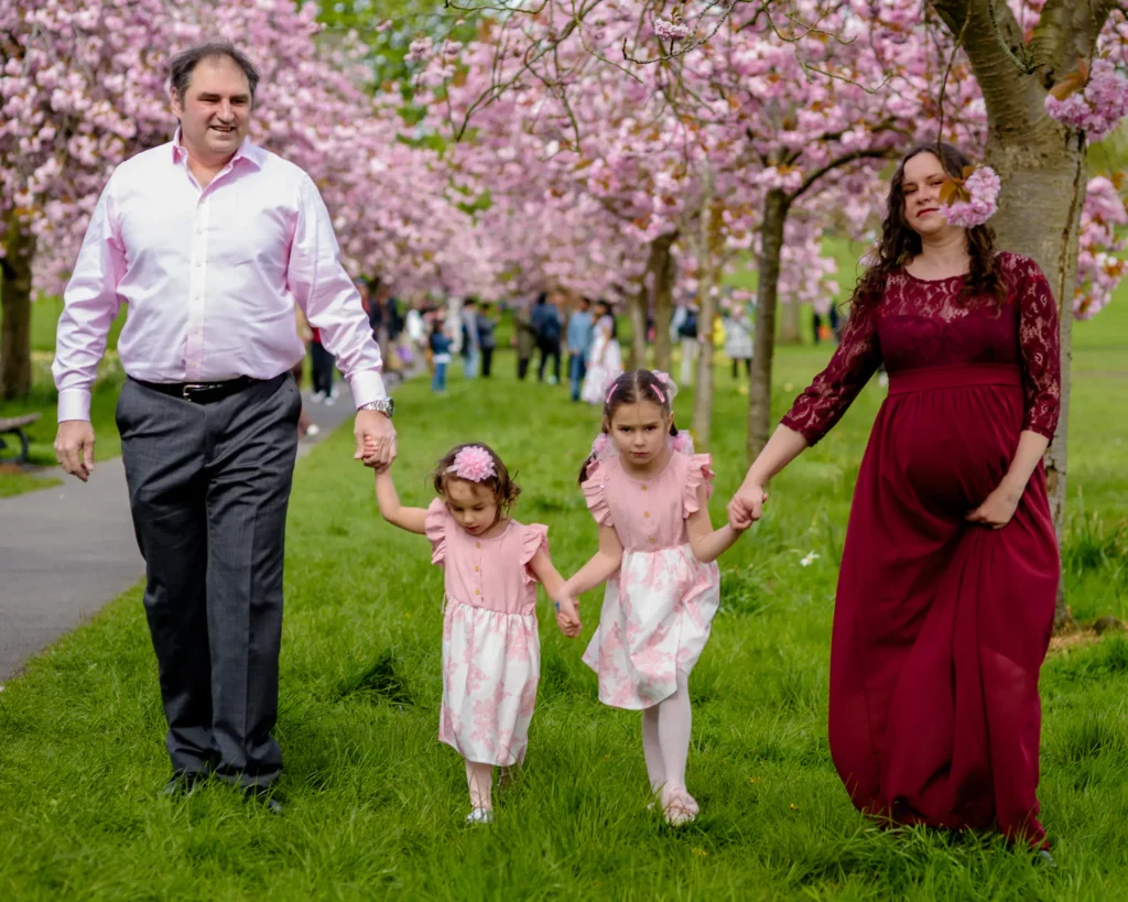 The family walking under the cherry blossom - by dick Lloyd Photography
