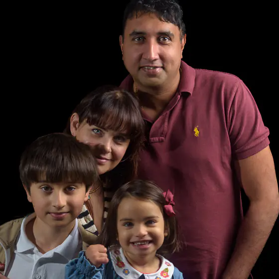 Relaxed family portrait taken on location with black background effect, by Yorkshire photographer Dick Lloyd