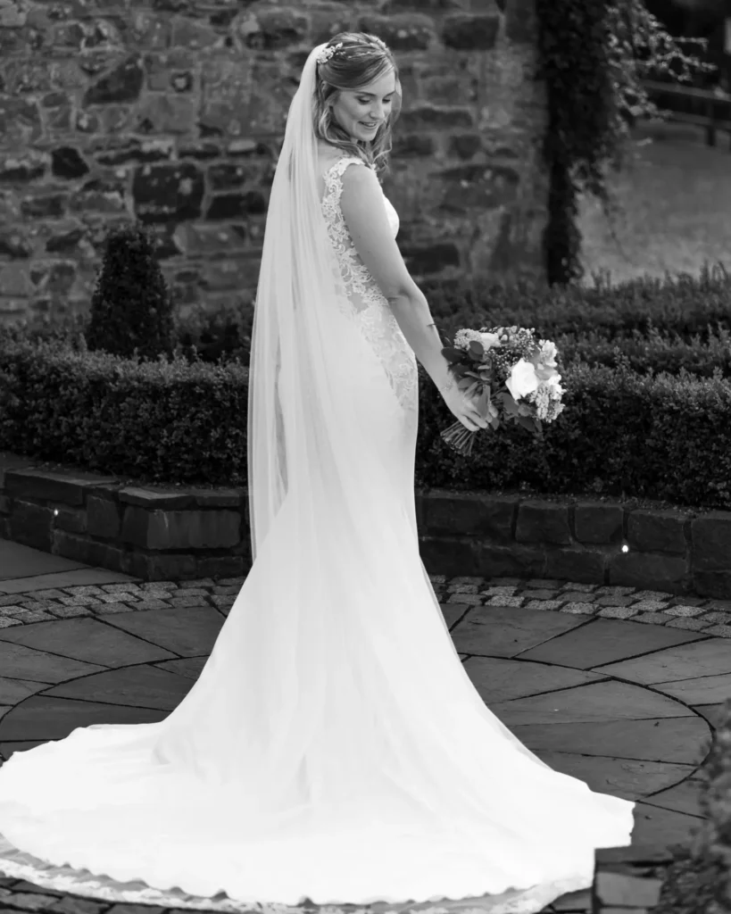 Angharad & Lewis Wedding-1083 Black & White portrait image of the bride in a quiet moment, showing off her wedding dress, captured by Dick Lloyd Photography