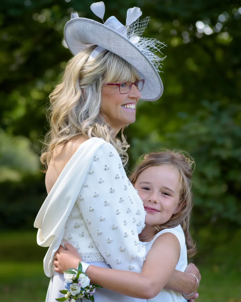Angharad & Lewis Wedding-1211 Flower girl hugging family member in candid moment full of emotion, Pembrokeshire wedding photography by Dick Lloyd Photography.
