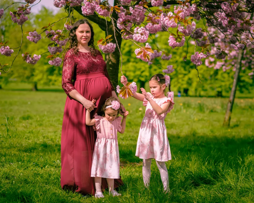 Iryna with her two daughters nder a cherry tree in blosson - by dick Lloyd Photography