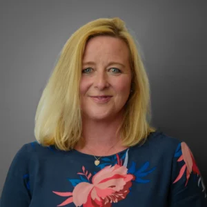 Woman in floral dress - headshot with grey background