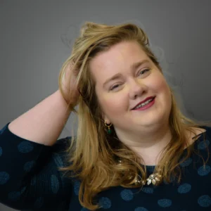 Woman posing with hand in hair - headshot with grey background